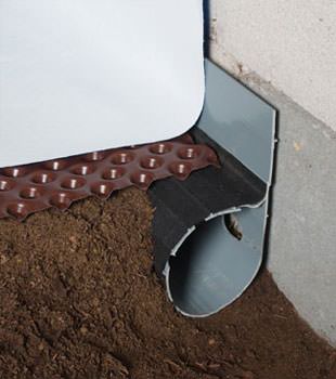 Closeup of a crawl space drainage system installed in Chambly