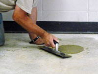 Repairing the cored holes in the concrete slab floor with fresh concrete and cleaning up the Terre-bonne home.